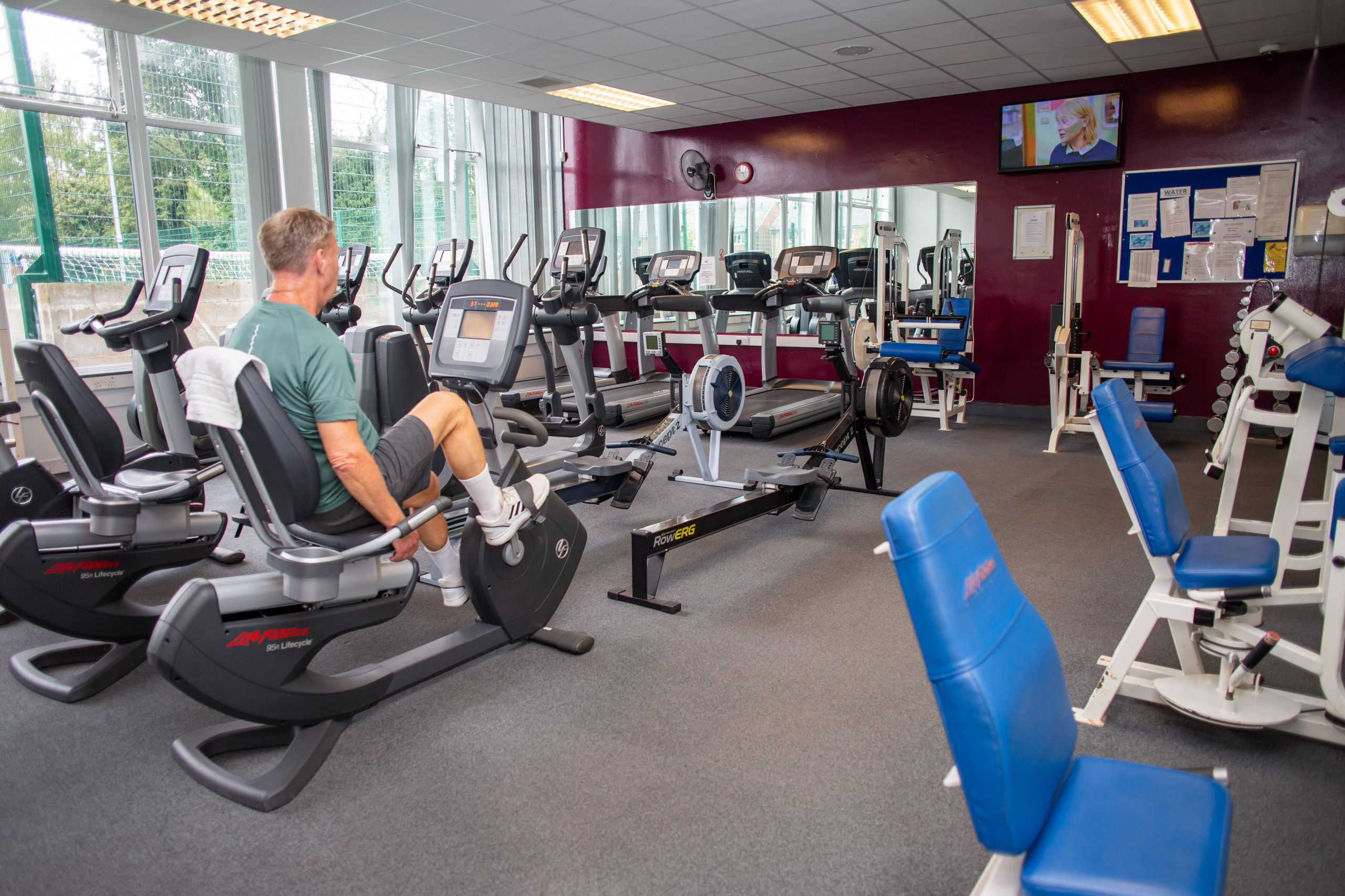 Gym with man operating exercise bike