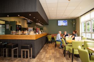 Inside of cafe bar with three women sat at a table