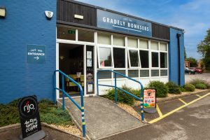 Outside of cafe building, blue building with Gradely Bonksers Cafe sign above windows.